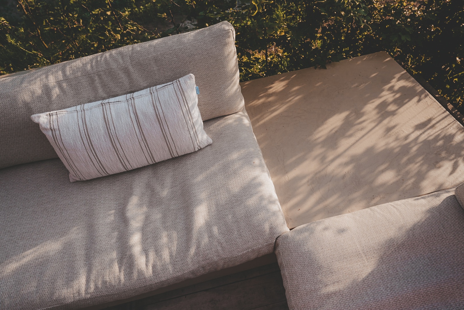 detail outdoorstof Fontelina beige (180) en sierkussen outdoor Sunbrella Harvest (19201)